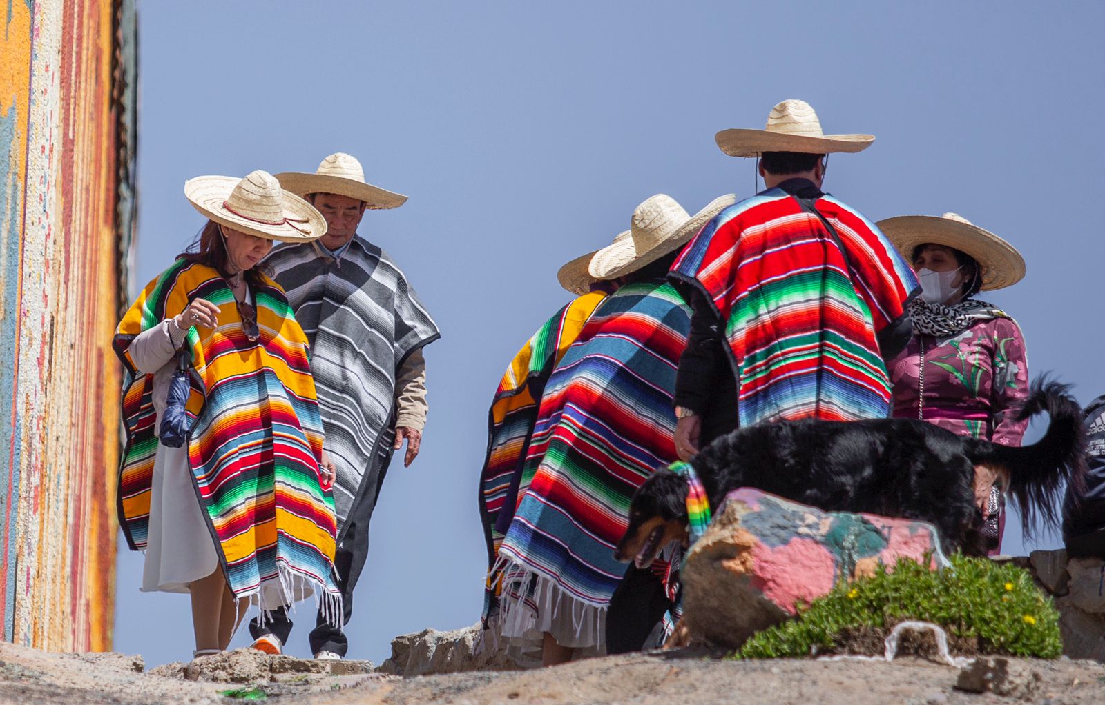 Fotonota Vestidos con un jorongo mexicano, turistas chinos se toman fotograf&iacute;as a un costado del muro fronterizo con Estados Unidos, en Playas de Tijuana